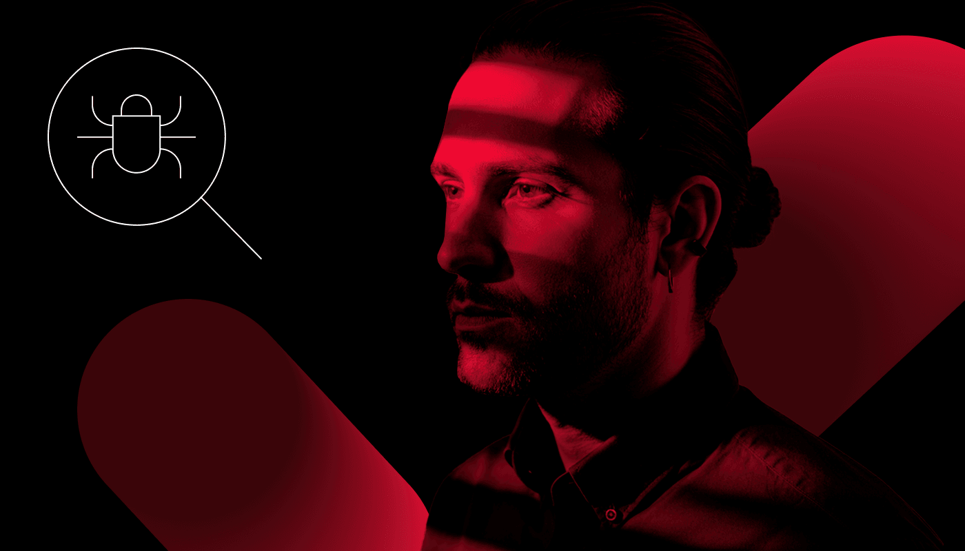 A man in the red and black shadows looks at the bug.